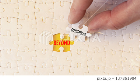 Beyond expectations words symbol. Concept words Beyond expectations on beautiful white puzzles. Beautiful yellow background. Businessman hand. Business Beyond expectations words concept. Copy space. 137861984