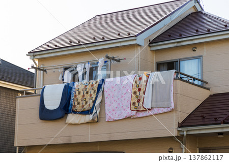 住宅の2階に干した布団と洗濯物 137862117