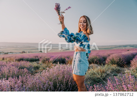 Woman lavender field summer smiling young woman holding glass with lavender in blooming field during sunset golden hour Woman lavender field summer smiling young woman holding glass with lavender in blooming field during sunset golden hour 137862712
