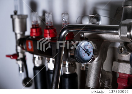 Complex residential heating manifold system with valves, gauges, and piping network Complex residential heating manifold system with valves, gauges, and piping network 137863095