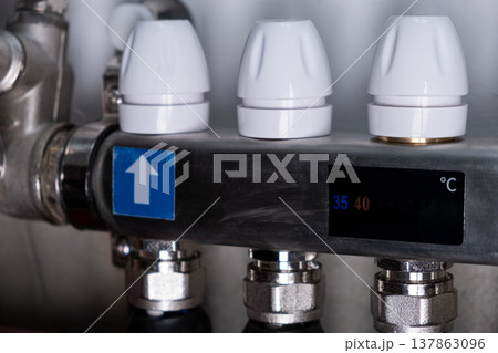 Complex residential heating manifold system with valves, gauges, and piping network 137863096