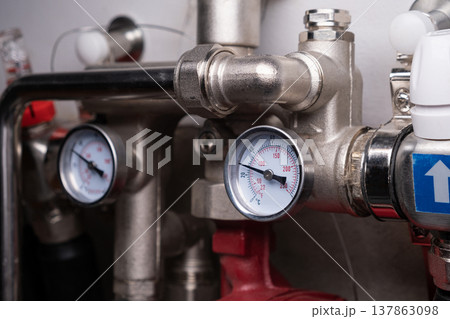 Complex residential heating manifold system with valves, gauges, and piping network 137863098