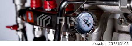 Complex residential heating manifold system with valves, gauges, and piping network. banner Complex residential heating manifold system with valves, gauges, and piping network. banner 137863108