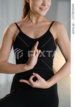 Woman practicing yoga poses indoors during a morning session in a bright studio 137864084
