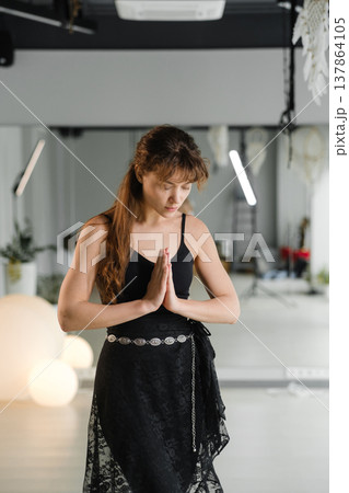 Woman practicing yoga in a studio with plants and soft lighting during a morning session for wellness and mindfulness Woman practicing yoga in a studio with plants and soft lighting during a morning session for wellness and mindfulness 137864105