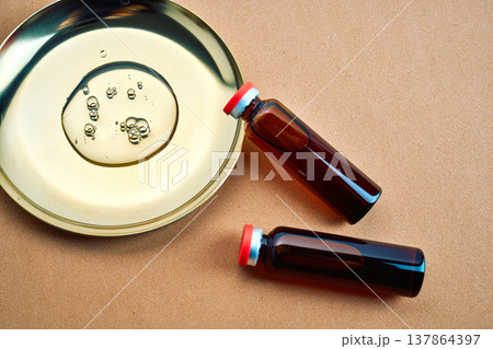 Skincare oil drops in petri dish with serum vials Skincare oil drops in petri dish with serum vials 137864397