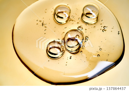 Golden transparent gel flowing with bubbling texture 137864437