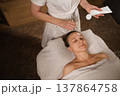 A relaxing spa treatment with skin care products for a woman who enjoys facials in a relaxed environment 137864758