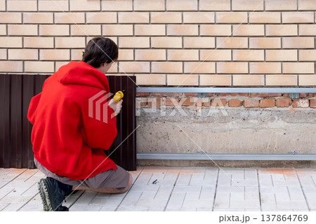 Worker installing house plinth with metal sheets during construction works 137864769