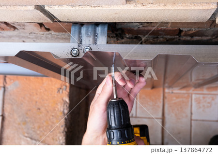 Repair of the foundation and walls of the house with the installation of metal sheets on the frame for finishing the basement. 137864772