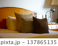 暖色系のクッションが並ぶ落ち着いた雰囲気のホテルのベッドルーム 137865135