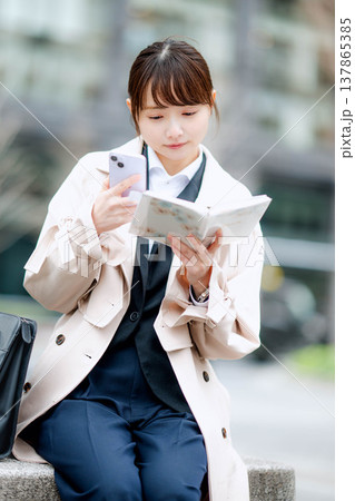 街中で携帯電話を使い通話する若いビジネスウーマン 137865385