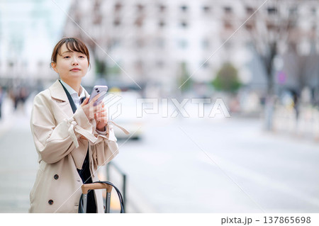 都会でタクシーを待つ若いビジネスウーマン 都会でタクシーを待つ若いビジネスウーマン 137865698