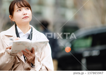 手帳を確認する若いビジネスウーマン 手帳を確認する若いビジネスウーマン 137865947