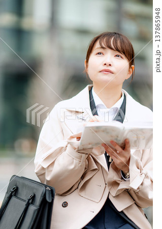 手帳を確認する若いビジネスウーマン 手帳を確認する若いビジネスウーマン 137865948