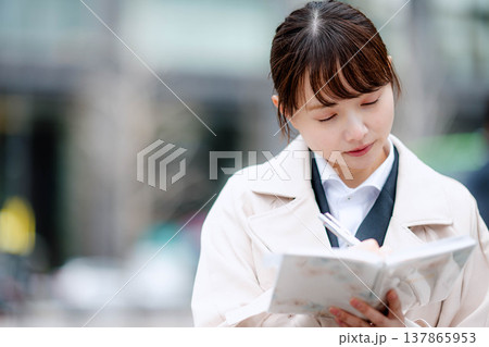 手帳を確認する若いビジネスウーマン 137865953