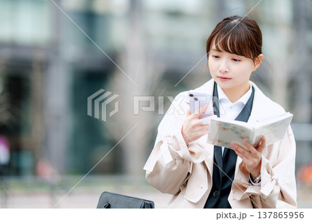 手帳を確認する若いビジネスウーマン 手帳を確認する若いビジネスウーマン 137865956