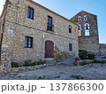 Rustic stone house and old church bell tower in Castellet village, Spain. 137866300