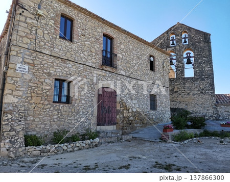 Rustic stone house and old church bell tower in Castellet village, Spain. 137866300