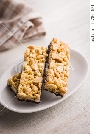 Stacked Peanut Granola Bars With Chocolate Coating On Plate, Crunchy Snack Food 137866671