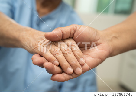 Caregiver holding hands Asian elderly woman patient, help and care in hospital. Caregiver holding hands Asian elderly woman patient, help and care in hospital. 137866746