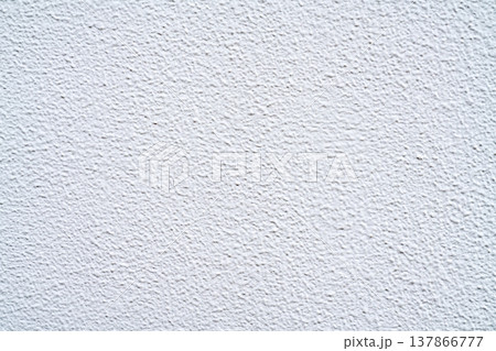 Close-up view of a white textured wall with a rough stippled finish. Clean minimal background for architecture, interior design, and construction themes. Grainy plaster surface with soft lighting. Close-up view of a white textured wall with a rough stippled finish. Clean minimal background for architecture, interior design, and construction themes. Grainy plaster surface with soft lighting. 137866777