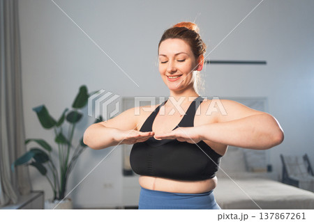 Fitness workout training. Woman practicing fitness at home. Plus size female doing sports exercise at home indoor. Girl in sportswear have workout weight training for weight loss. Sport and fitness Fitness workout training. Woman practicing fitness at home. Plus size female doing sports exercise at home indoor. Girl in sportswear have workout weight training for weight loss. Sport and fitness 137867261