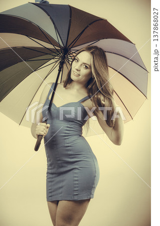 Woman in summer dress holds umbrella 137868027