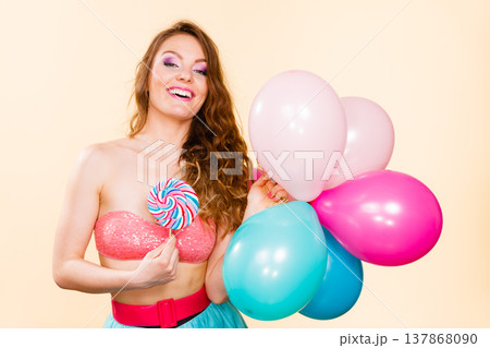 Woman holds lollipop candy and balloons Woman holds lollipop candy and balloons 137868090