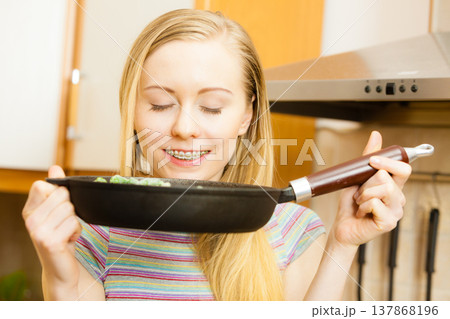 Woman cooking stir fry frozen vegetable on pan Woman cooking stir fry frozen vegetable on pan 137868196