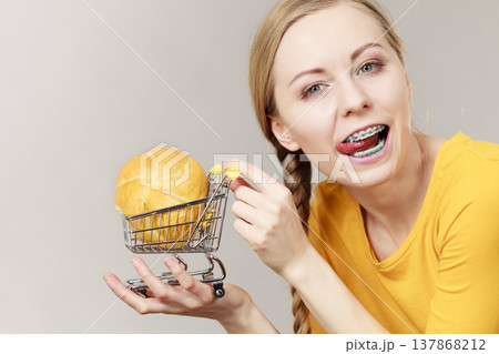 Woman holding shopping cart with bread Woman holding shopping cart with bread 137868212