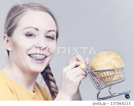 Woman holding shopping cart with bread Woman holding shopping cart with bread 137868213