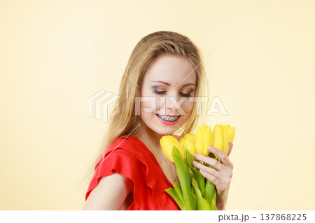 Pretty woman with yellow tulips bunch 137868225