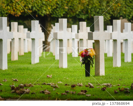Crosses stand in a row as flowers sit at a grave in a cemetery where people remember their loved ones 137868694