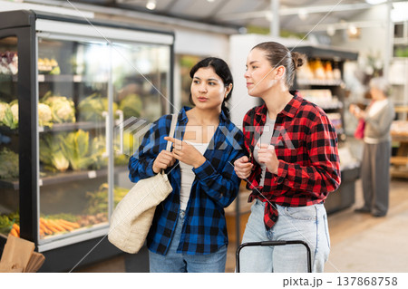 Two friends are choosing something in grocery supermarket 137868758