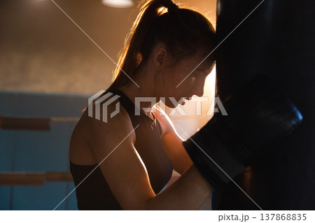 Women self defense girl power. Strong woman fighter resting after fight training on boxing ring. Strong girl tired after punching boxing bag. Training day in gym. Strength fit body workout training 137868835