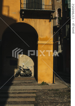 Motorcycle on a street of the old city Verona, Italy. Beautiful morning sunlight. 137868952