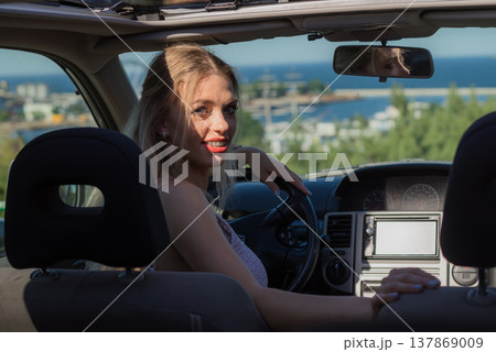Young driver woman behind steering wheel 137869009