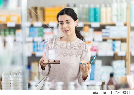 Young woman chooses cosmetics at pharmacy 137869091