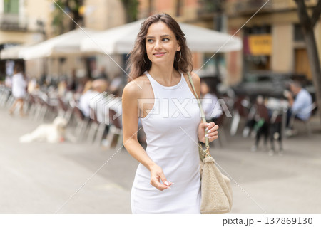 Young woman looks around at street cafes Young woman looks around at street cafes 137869130
