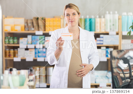 Pregnant woman pharmacist offering pills Pregnant woman pharmacist offering pills 137869154