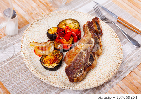 on blue plate-grilled beef ribs with fried vegetables-aubergine, pepper,onion 137869251