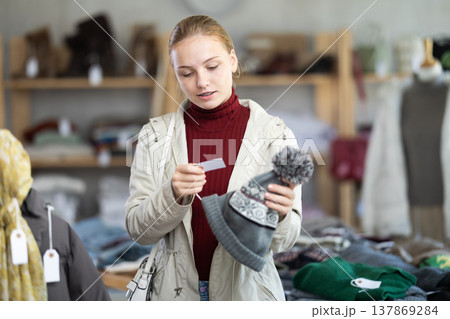 Teenage girl choosing hat in clothing store Teenage girl choosing hat in clothing store 137869284