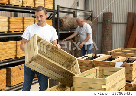 Man florist looking for functional wooden box for growing flowers 137869436