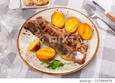 Grilled beef spare ribs with baked potatoes and greens Grilled beef spare ribs with baked potatoes and greens 137869476