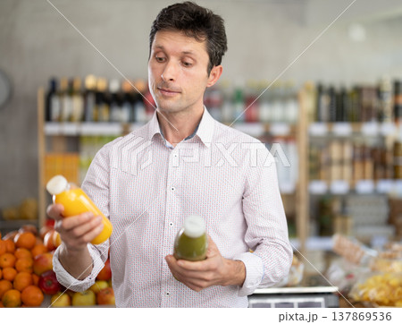 Adult man chooses yellow and green smoothie 137869536