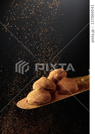 Chocolate truffles on a vintage brass cake server. 137869541