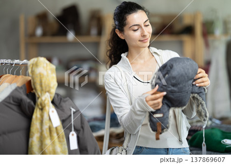 Armenian woman near showcase examine goods, fur hat. 137869607