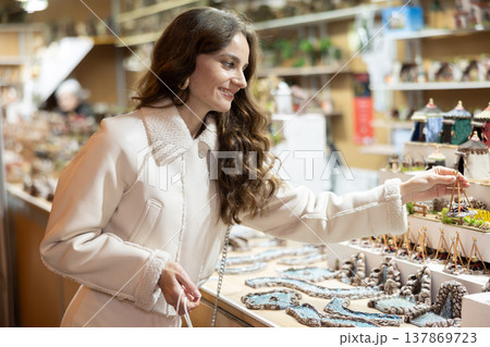 Woman choosing Christmas figurines Woman choosing Christmas figurines 137869723