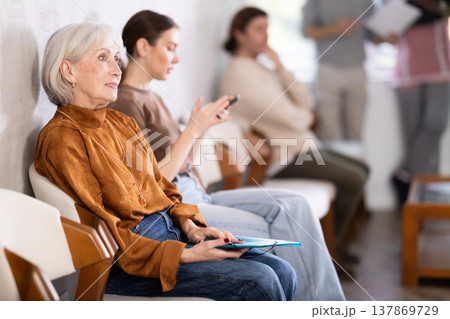 People are sitting in line and waiting for an interview People are sitting in line and waiting for an interview 137869729